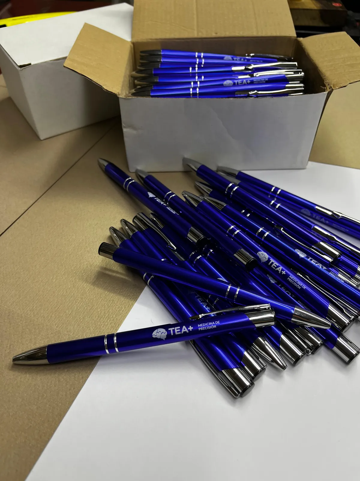 Bolígrafos metálicos azules grabados con el logo de TEA+