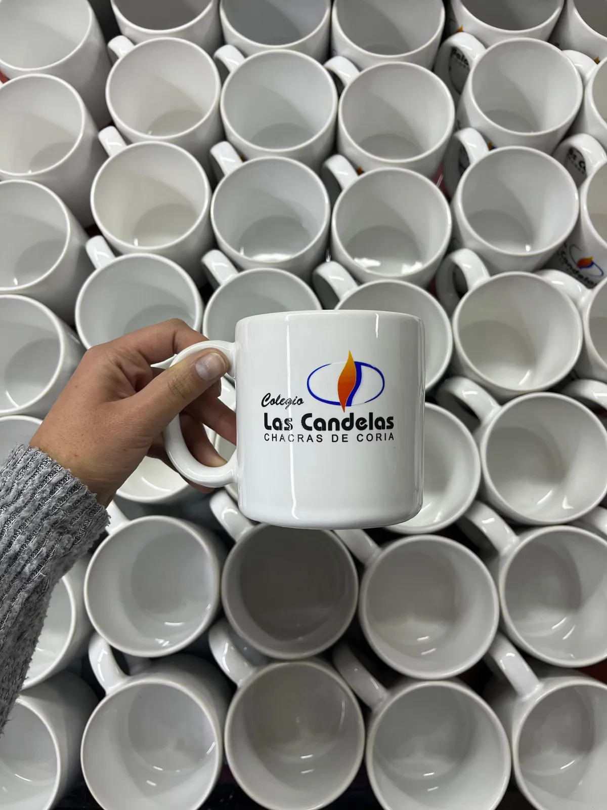 Pila de tazas de cerámica sublimadas con el logo del Colegio Las Candelas